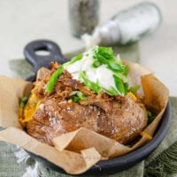 Side view of a fully loaded pulled pork baked potato.