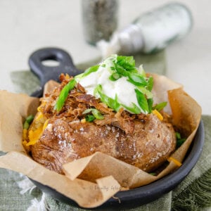 Side view of a fully loaded pulled pork baked potato.