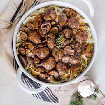 Closeup of a large serving bowl with salisbury steak meatballs in it.