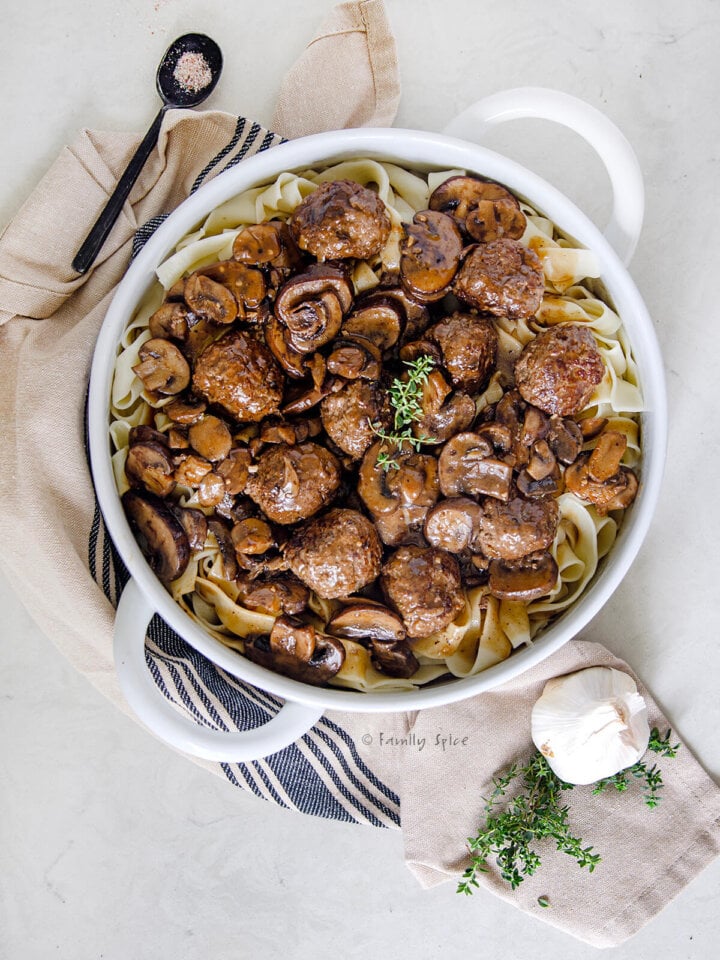 Closeup of a large serving bowl with salisbury steak meatballs in it.