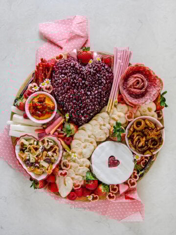 A valentine charcuterie board on a round wooden tray.