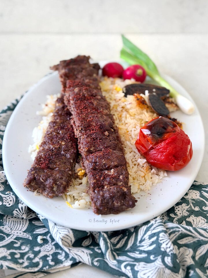 Closeup of a plate with oven baked koobideh kabob on basmati rice.